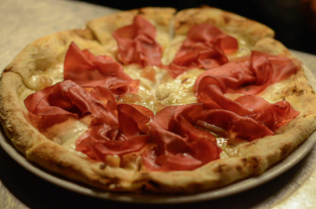 pizza al prosciutto realizzata artigianalmente nel forno del laboratorio a vista di Salamensa